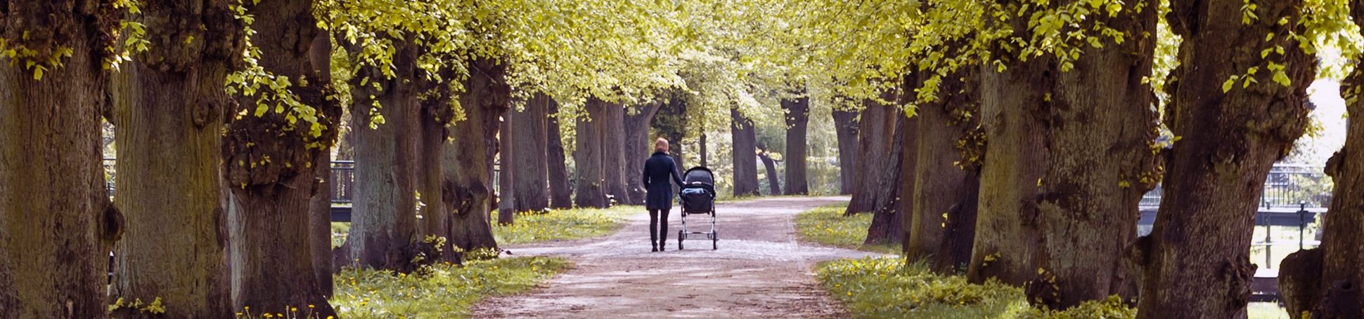 Mutter mit Kinderwagen im Park