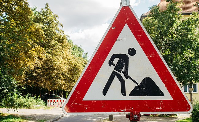 Baustellenschild auf Straßenhintergrund  