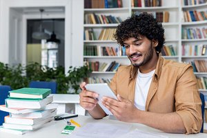 Junger Mann recherchiert mit einem Tablet