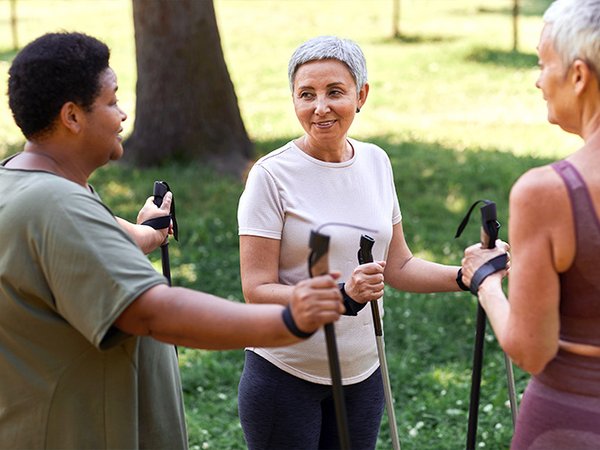 Drei ältere Frauen machen Nordic Walking