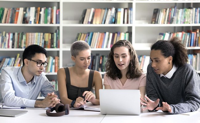 Gruppe von Jugendlichen recherchiert vor dem Laptop