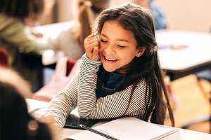 Mädchen lacht in einer Grundschulklasse Mädchen lacht in einer Grundschulklasse