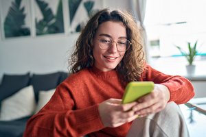 Eine junge Frau schaut auf ihr Smartphone Eine junge Frau schaut auf ihr Smartphone