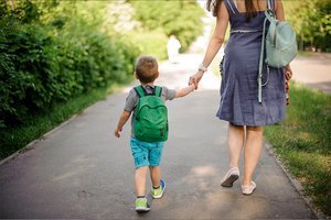 Kleiner Junge geht mit der Mutter die Straße entlang Kleiner Junge geht mit der Mutter die Straße entlang