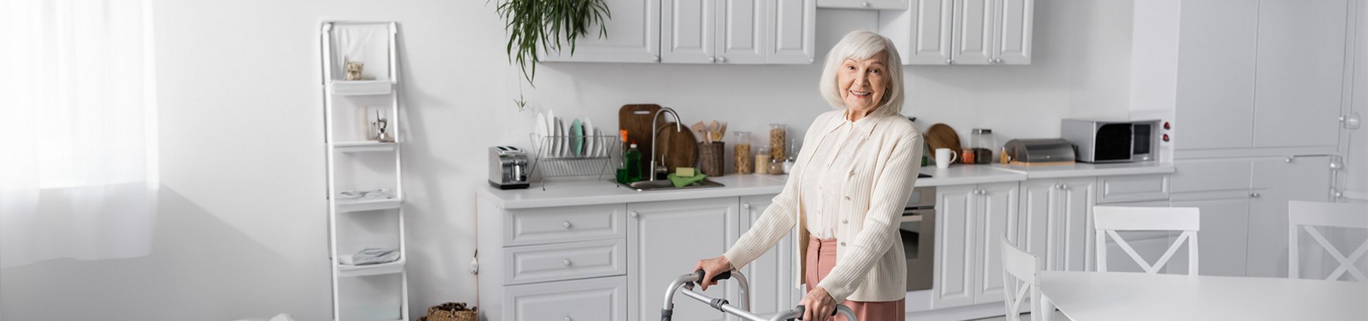 Seniorin läuft mit Rollator durch ihre Wohnung
