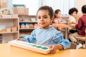 Kleines Mädchen spielt mit Holzspielzeug in Kita Kleines Mädchen spielt mit Holzspielzeug in Kita