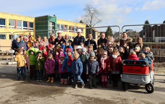 Die Kinder der Kindertageseinrichtung „Pusteblume“ freuen sich zusammen mit ihren Erzieherinnen und Erziehern sowie der Kindergartenleitung Birgit Scholz auf das neue Gebäude. Das haben sie Bürgermeister Fred Toplak,Dr. Karsten Schneider (Beigeordne