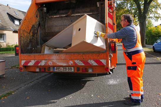 Müllwerker Guiseppe Taormina bei der Arbeit. Gleich ein ganzer Schrank wird in dem Sperrmüllwagen zerkleinert. Müllwerker Guiseppe Taormina bei der Arbeit. Gleich ein ganzer Schrank wird in dem Sperrmüllwagen zerkleinert.