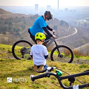 Kleiner Junge und Jugendlicher mit Fahrrad auf Halde Hoheward