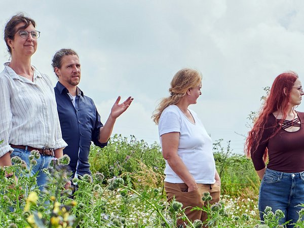 Gruppe steht in einr Wildwiese