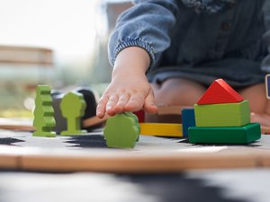 Kind spielt mit Holzbausteinen