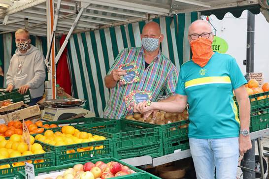 Bürgermeister Fred Toplak (rechts) verteilt die neue Marktbroschüre auf dem Wochenmarkt in Herten.