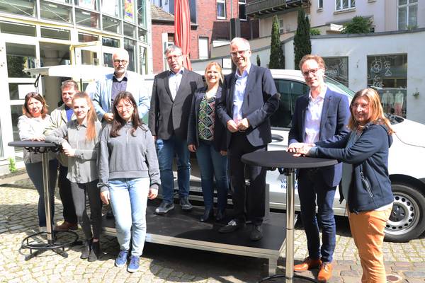 (Auf der Bühne von links nach rechts) Bürgermeister Matthias Müller, Hermann Pieper, Beigeordneter für Bildung und Soziales, Stefanie Dobberke, VHS-Leitung, und Ingo Abrahams, Vorstandsmitglied der Volksbank Ruhr Mitte, freuen sich zusammen mit dem anwesenden KuBi-Mobil-Team über den Erfolg des Projekts.