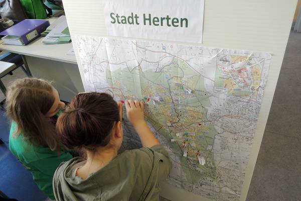 Am Anfang hat jedes Kind eine Arbeitsmappe, mit seinem Namen und einem Foto erhalten.
Mit Hilfe eines Stadtplans von Herten, Stecknadeln und Namenszetteln, markieren die Kinder ihren eigenen Wohnort.