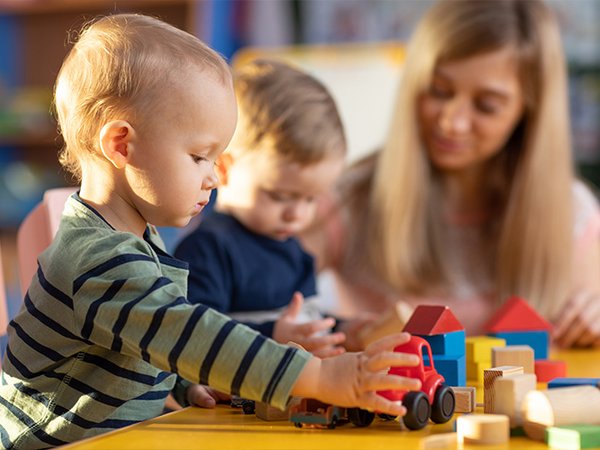 Kleine Kinder spielen mit Holzbausteinen