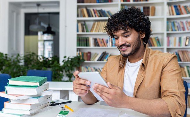Junger Mann recherchiert mit einem Tablet