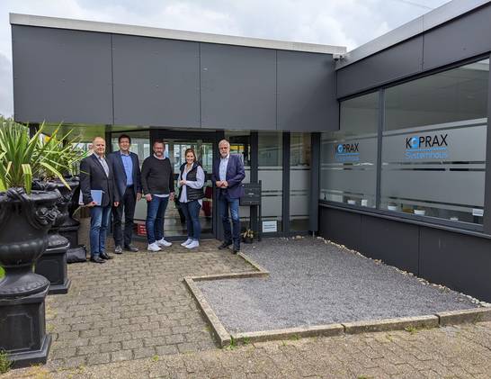 Bürgermeister Matthias Müller (l.) sowie Christian Kubienski vom Jobcenter Kreis Recklinghausen und Michael Blume, Leiter der Wirtschaftsförderung (v.l.), begrüßen Danica Wichmann und Dennis Laser vom IT-Systemhaus Koprax am neuen Unternehmensstandort in Herten.