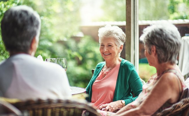 Seniorinnen sitzen bei einem gemeinsamen Drink