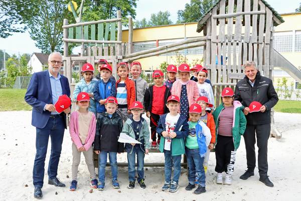 Die Vorschulkinder der Kita „Pusteblume“ in Herten mit den signalroten DEKRA-Kappen. Bürgermeister Matthias Müller (links) und Carsten Debler, Niederlassungsleiter der DEKRA Niederlassung Essen, verteilten die Kappen, damit die Kinder bei ihrem Weg zur Schule sicher sind.
