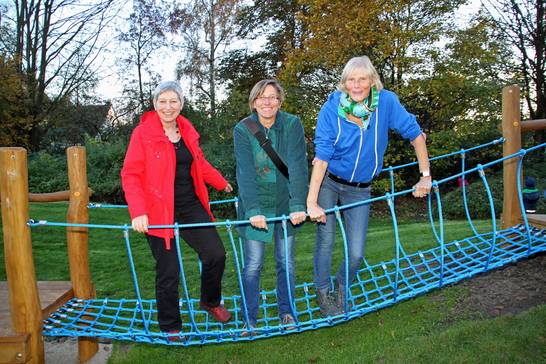 Susanne Rühl (ZBH), Ilka Koelsch (Stadtverwaltung) und Beaten Kleibrink (Kinderfreunde) testen das neue Spielgerät. 