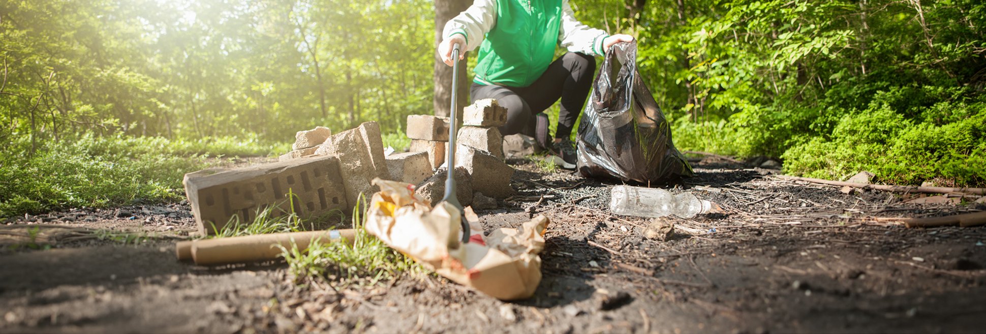 Jemand sammelt Müll im Wald