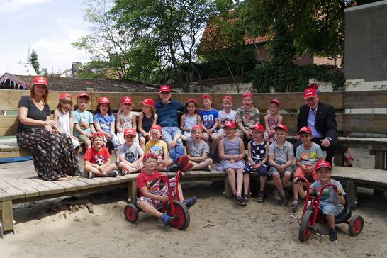 Dekra-Niederlassungsleiter Carsten Debler verteilte gemeinsam mit Bürgermeister Fred Toplak signalrote Sicherheitskappen an die zukünftigen Erstklässlerinnen und Erstklässler des Kindergartens Distelpink in Herten-Disteln.