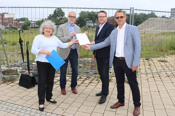Von der Brache zum neuen Forum Herten. Stadtbaurätin Janine Feldmann und Bürgermeister Matthias Müller haben den Vertretern der Investorengesellschaft Dr. Stephan Schnitzler, Geschäftsführer der Phoenix development GmbH aus Bonn/Weiden, und Arkadiusz Korzeniecki, Leiter Baumanagement bei der Phoenix development, (v.l.) jetzt offiziell die Teilgenehmigung überreicht.