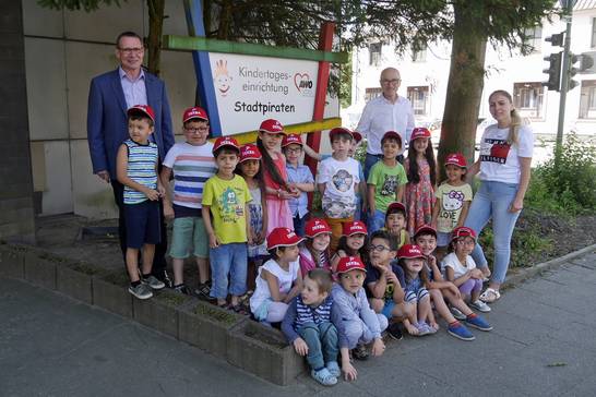 Die Kinder des AWO-Kindergartens Stadtpiraten freuen sich über ihr signalroten Kappen.