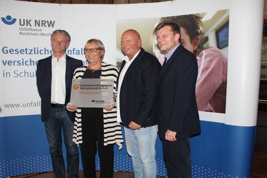 Die Schulleiterin Renate Kopka-Pullwitt nimmt den Preis mit Schulrat Andreas Menzel (links), Jörg Kersten, vom Bereich Schule und Sport (rechts) und dem stellvertretenden Schulleiter Christian Witlak (zweiter von rechts) an.