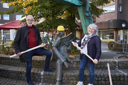 Waren gut gelaunt und tatkräftig beim Startschuss für den "Baustart Ewaldstraße" dabei: Bürgermeister Matthias Müller (l.) und Janine Feldmann, Erste Beigeordnete, dazwischen die Bronzeplastik "Lesender", passend mit Schutzhelm (Foto: Martin Schmüdderich).